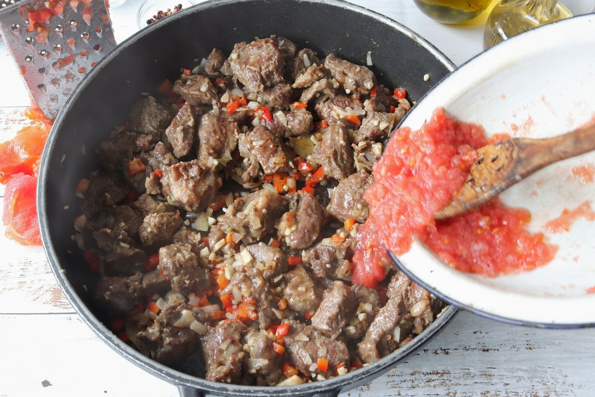 Añadir tomate rallado caldereta de carne de ternera
