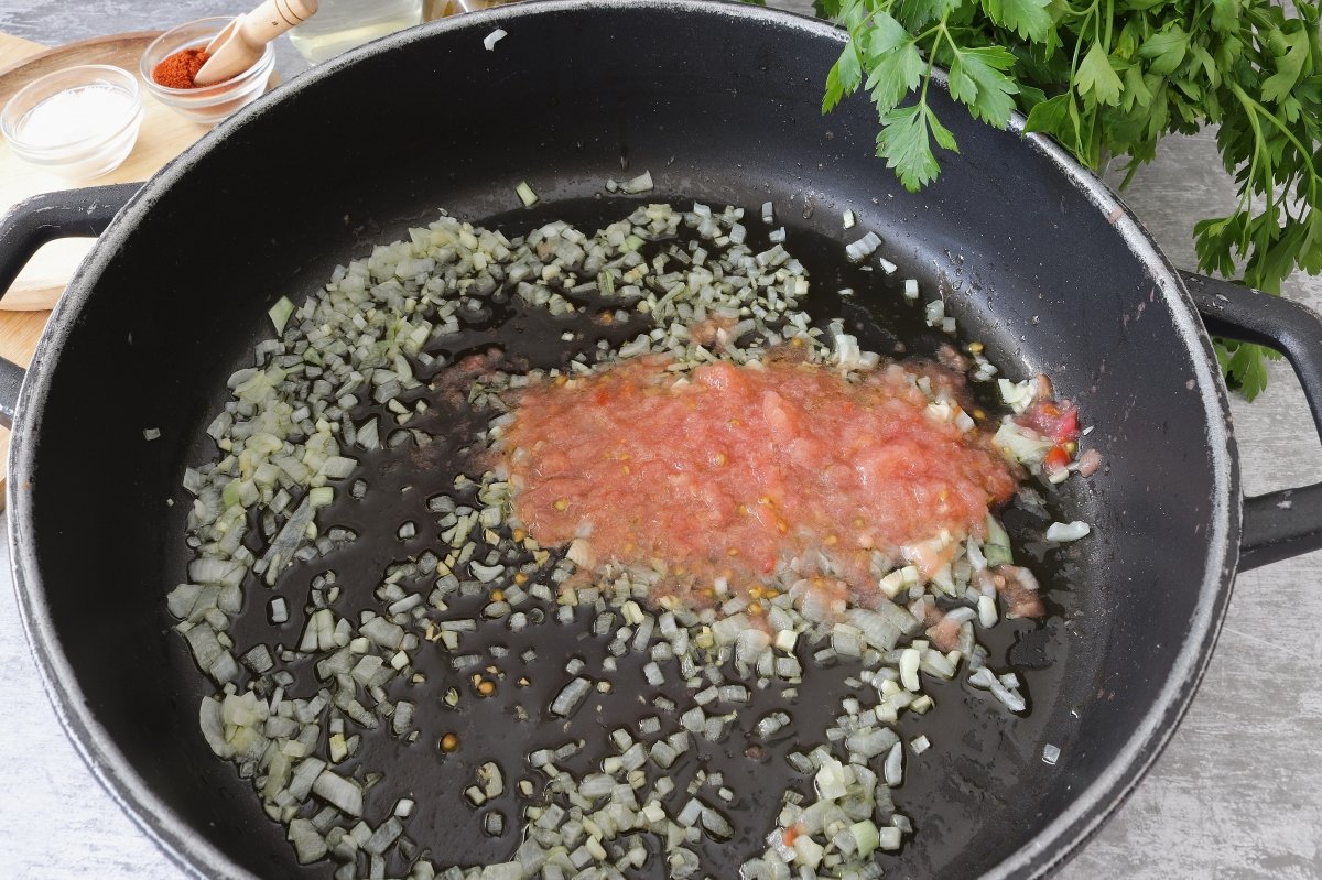 Añadir tomate rallado guiso de merluza con patatas