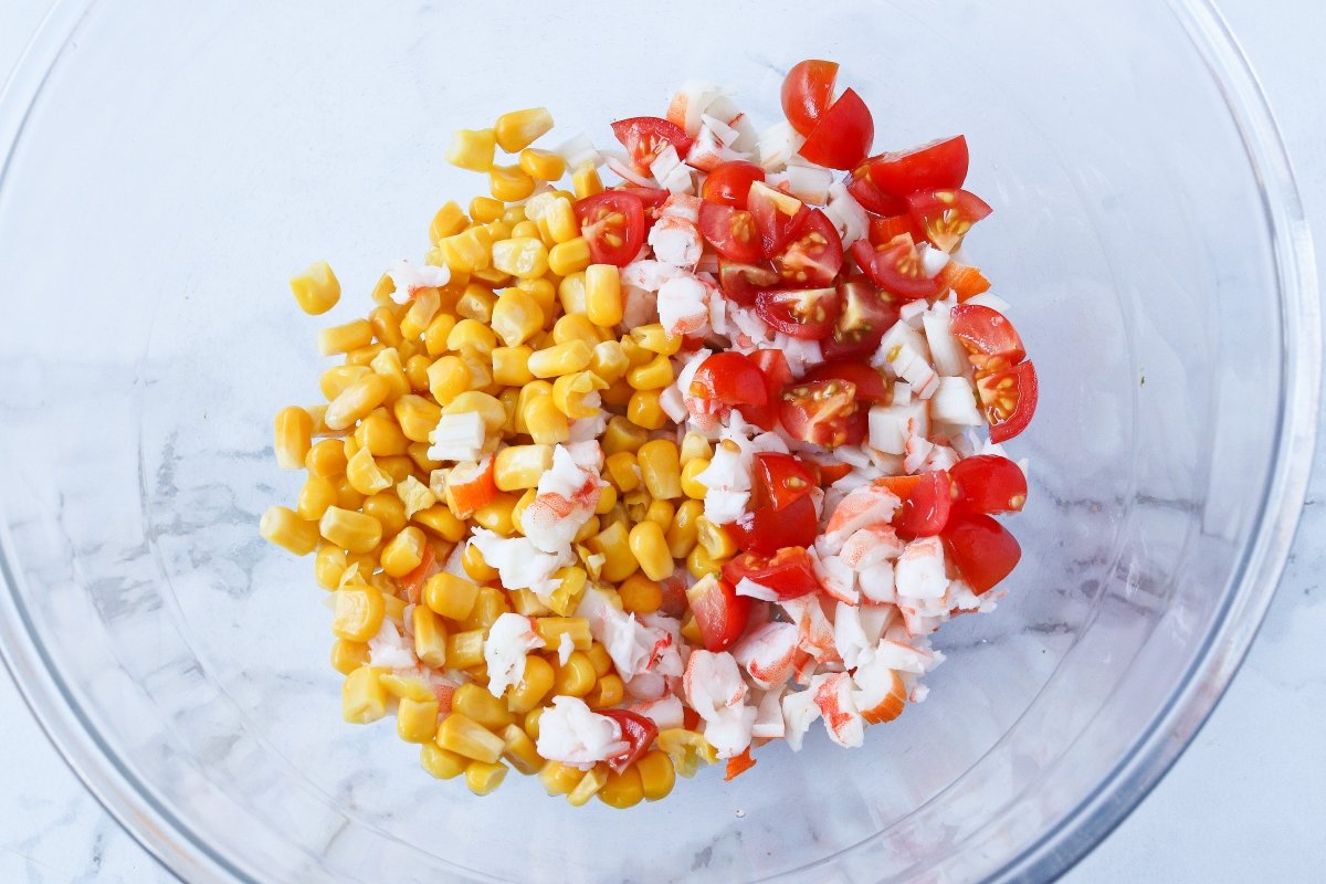Añadir tomates cherry y maíz a los aguacates rellenos