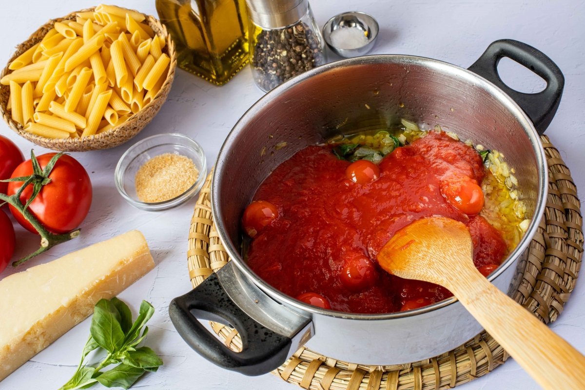 Añadir tomates triturados para hacer la salsa de los macarrones a la napolitana