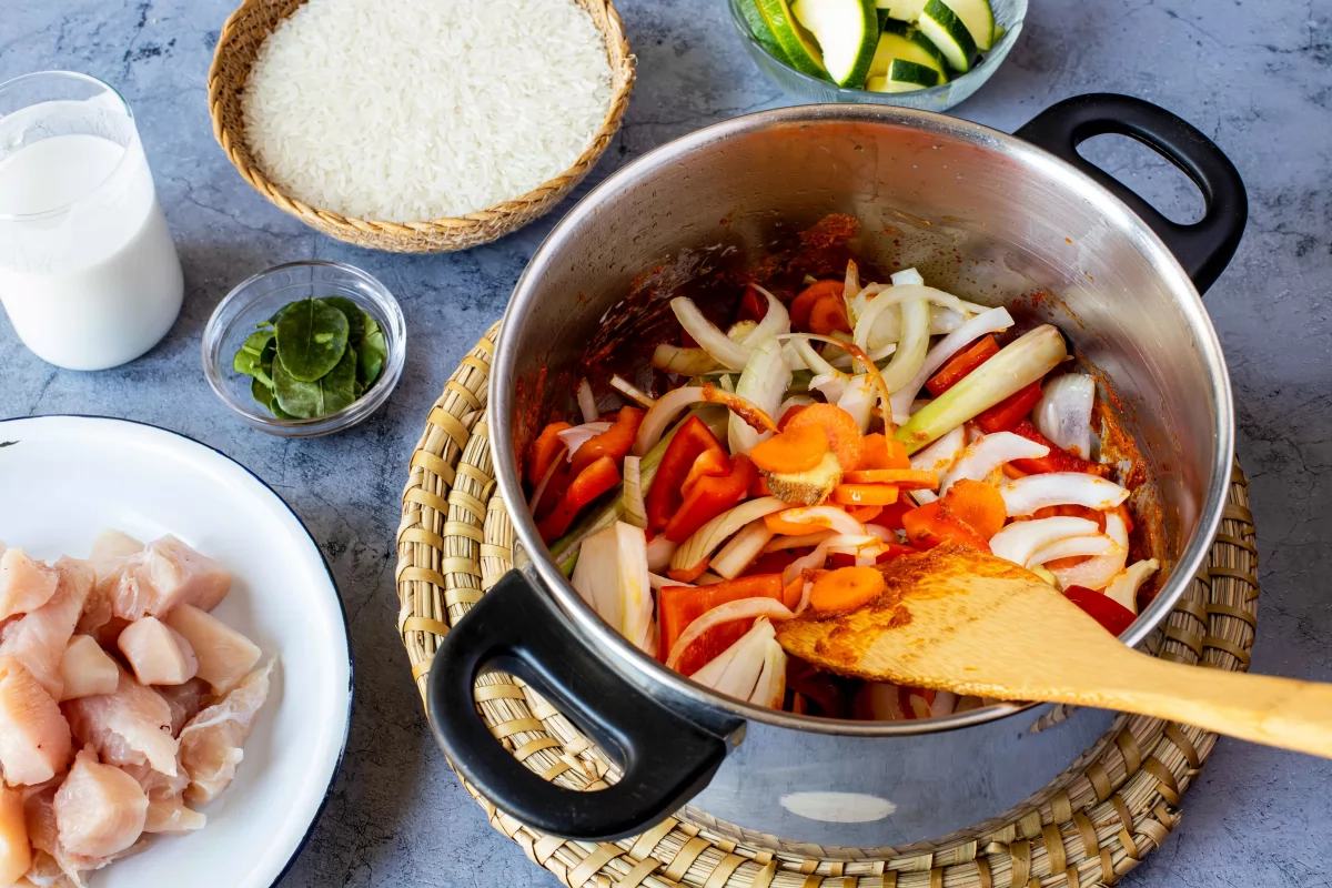 Añadir verduras a la olla para hacer el curry rojo de verduras y pollo *