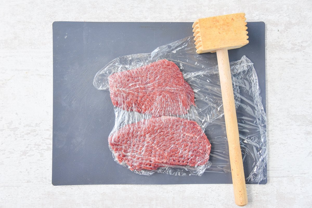 Aplastamos la carne para hacer el bistec encebollado