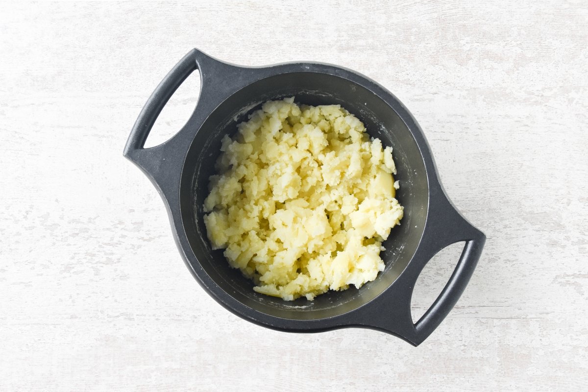 Aplastamos las patatas hervidas para el pastel de patatas y atún