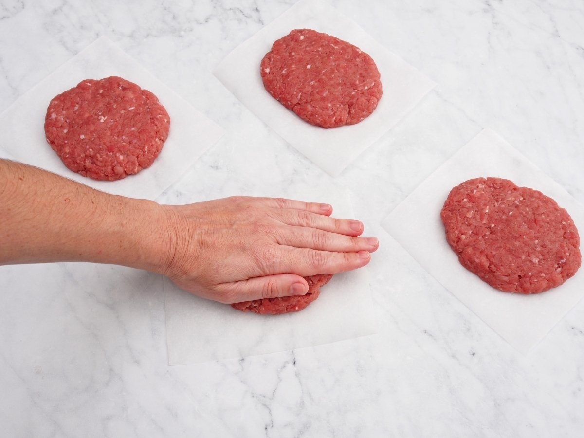 Aplastar las bolas de masa de la hamburguesa de carne de ternera casera
