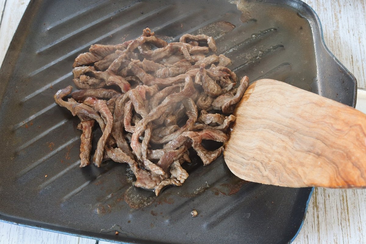 Asar la carne para el Philly cheesesteak