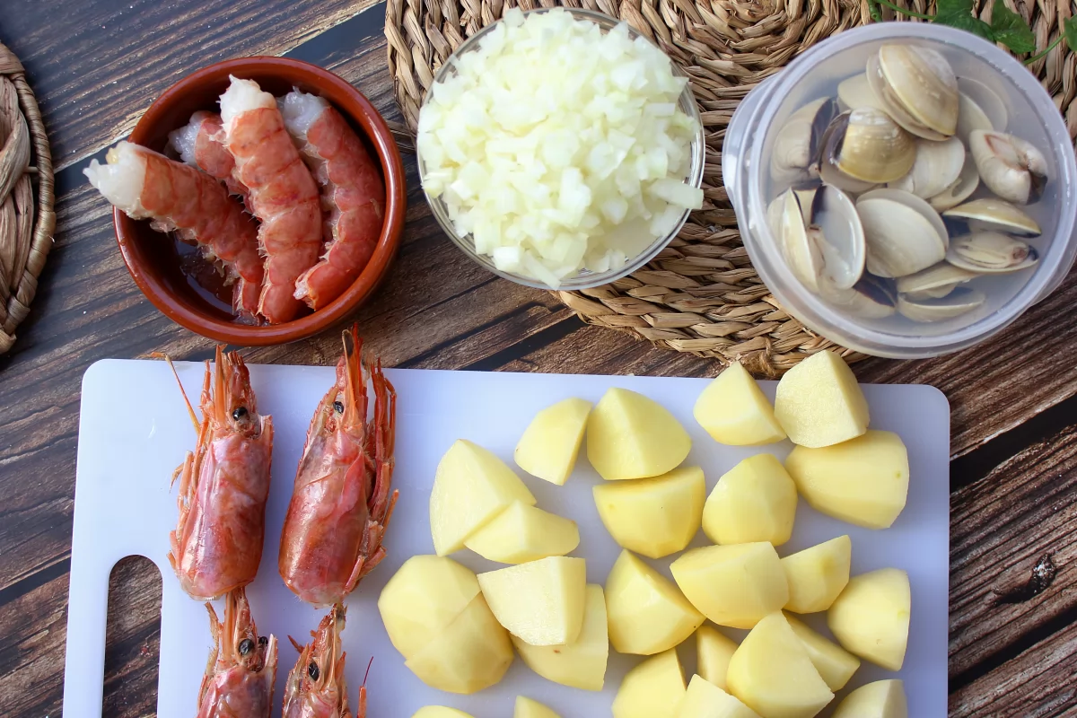 Aspecto de los gambones, almejas, patatas y cebolla para el guiso