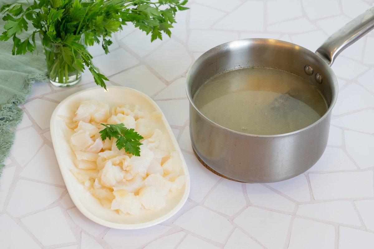 Bacalao desmenuzado y caldo listo para hacer arroz caldoso con bacalao