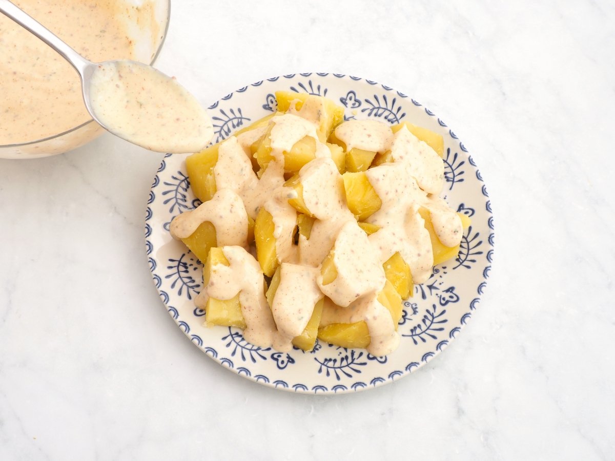 Bañar las patatas con la salsa