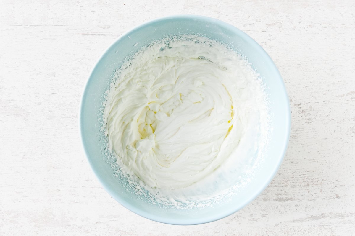 Batimos la nata con el azúcar glas para la mousse de yogur