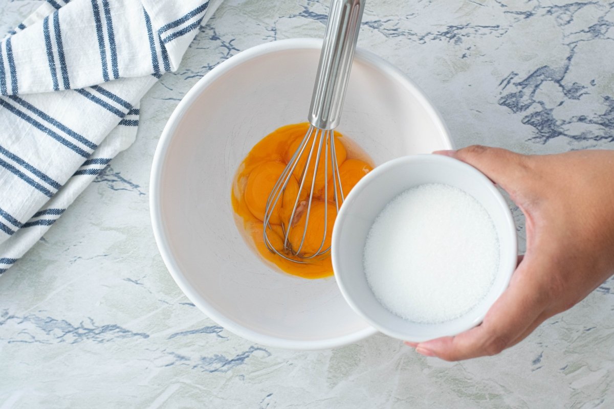 Batir el azúcar y las yemas para preparar la crema pastelera de los miguelitos