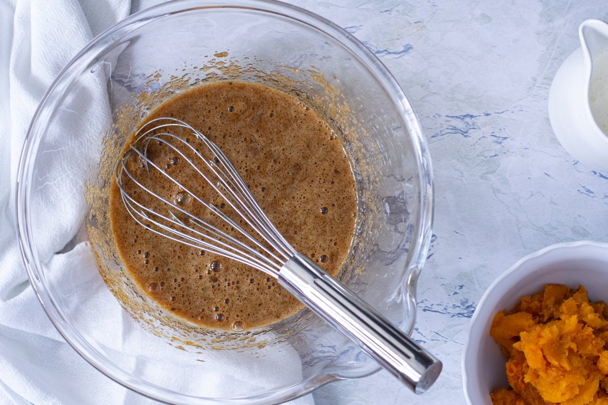 Batir los huevos con el azúcar para hacer el bizcocho de la tarta de calabaza