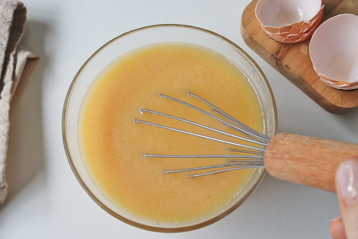 Batir los huevos en el caldo para el caldo de gallina