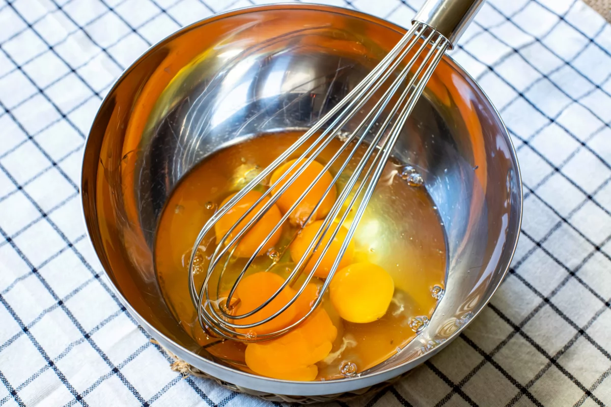 Batir los huevos para el revuelto de morcilla de Burgos con pasas *