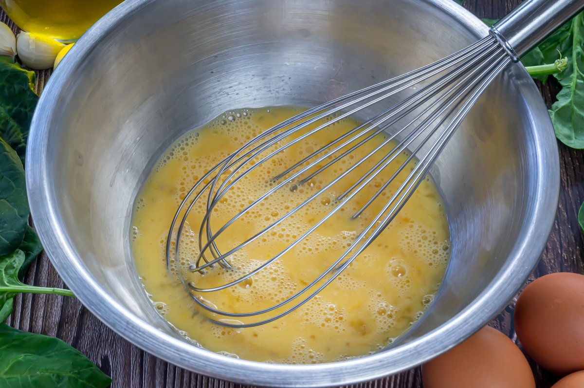 Batir los huevos para la tortilla de espinacas
