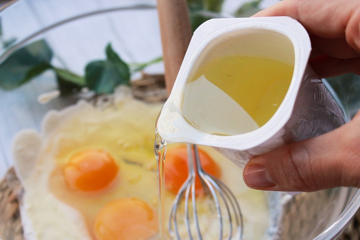 Bol con yogur, huevos y aceite para el bizcocho con dátiles