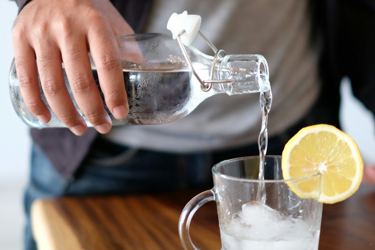 Botella de agua reusable al servir un vaso de agua