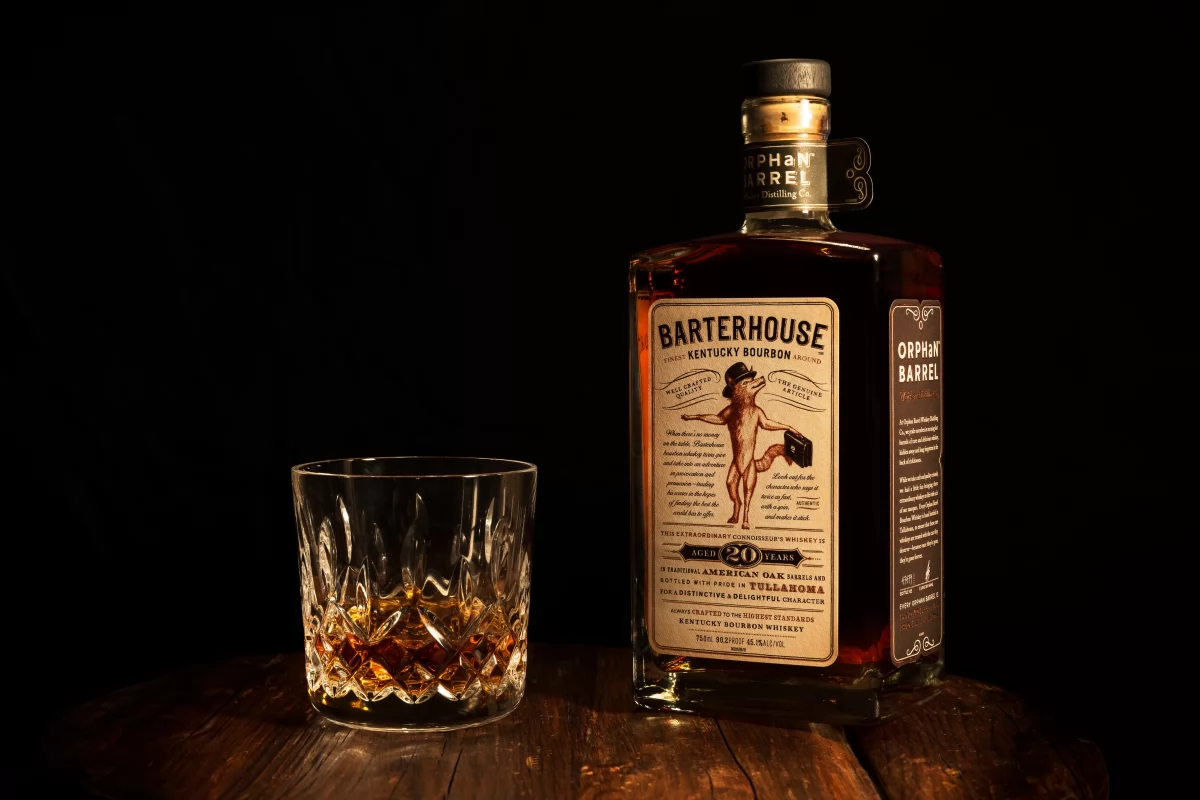 Botella de whisky bourbon y un vaso de cristal con bebida