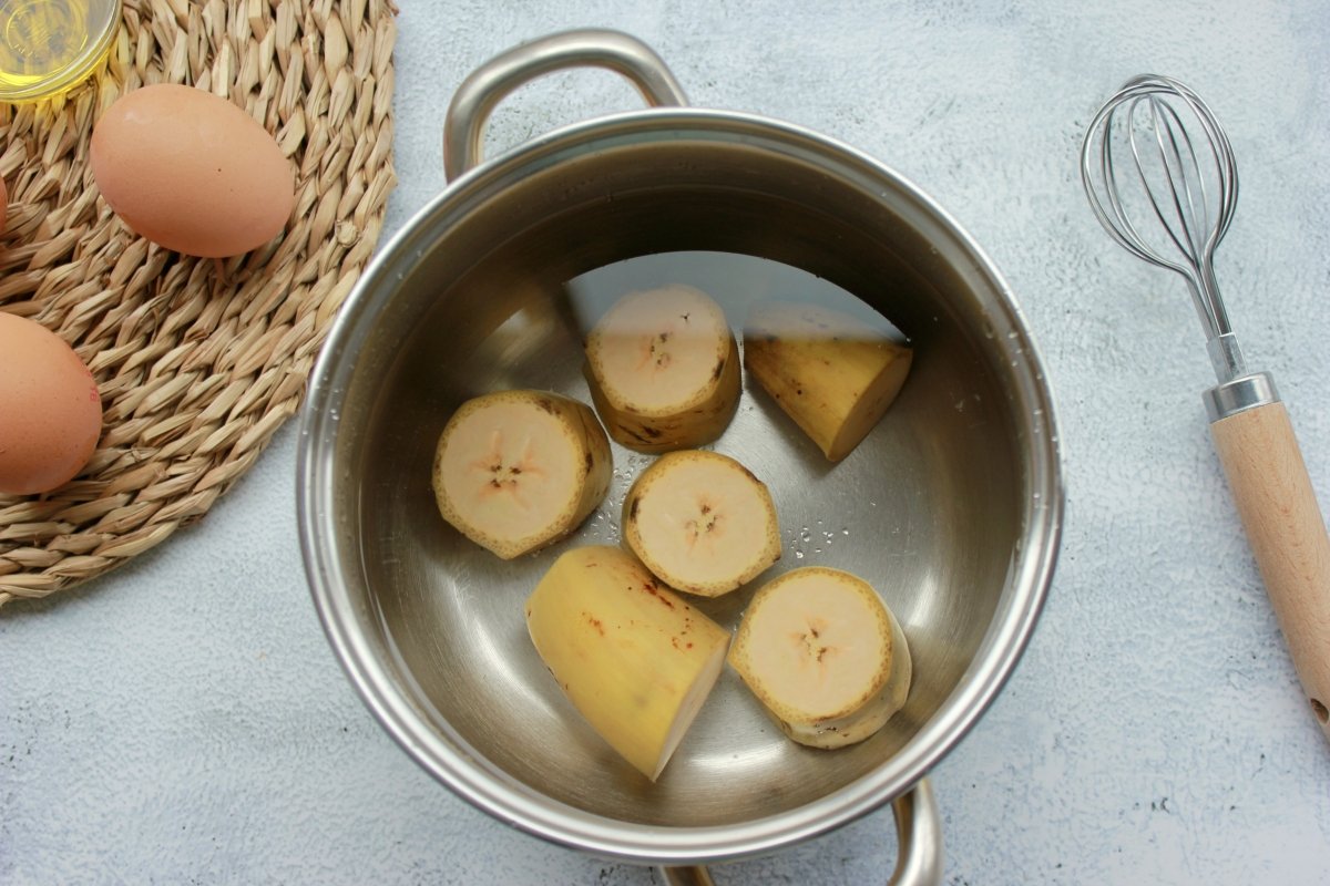 Cacerola llena de agua y con el plátano cortado el rodajas