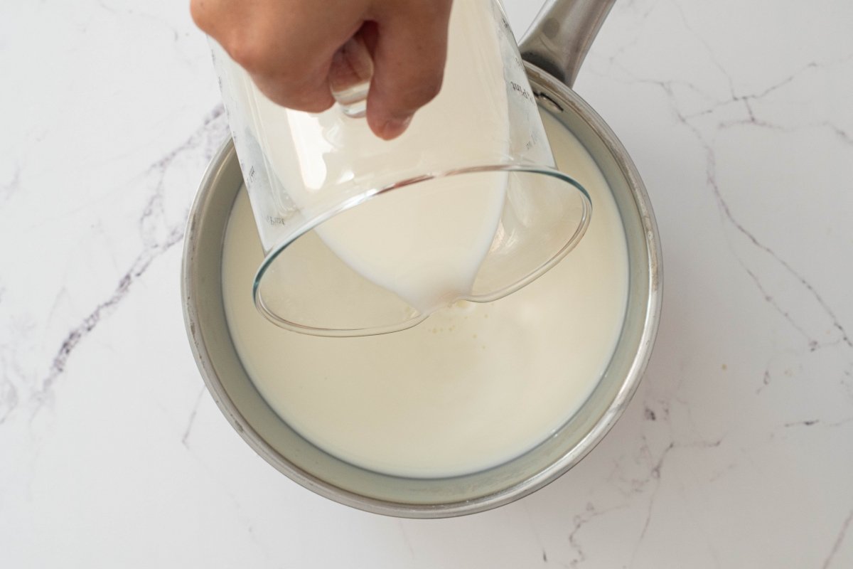 Calentamos la leche de la tarta de galletas y natillas