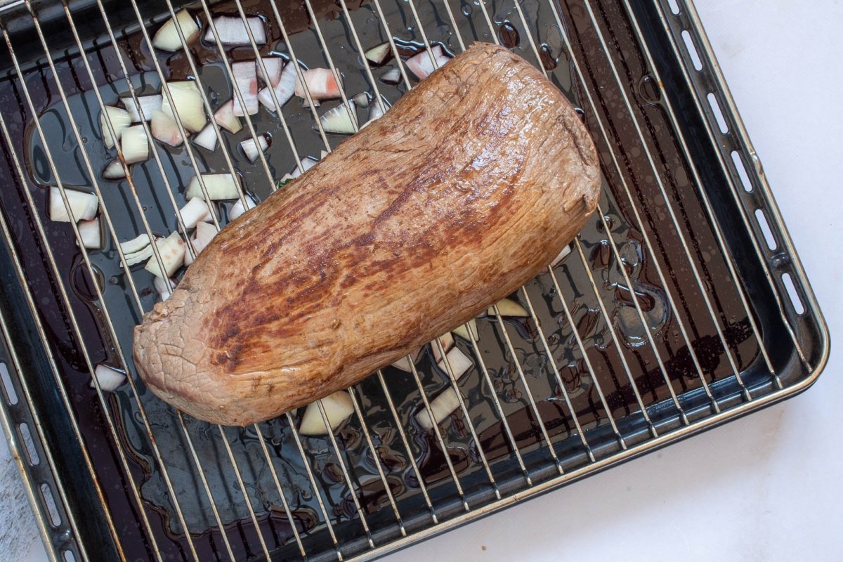 Carne marcada sobre rejilla de horno lista para hornear