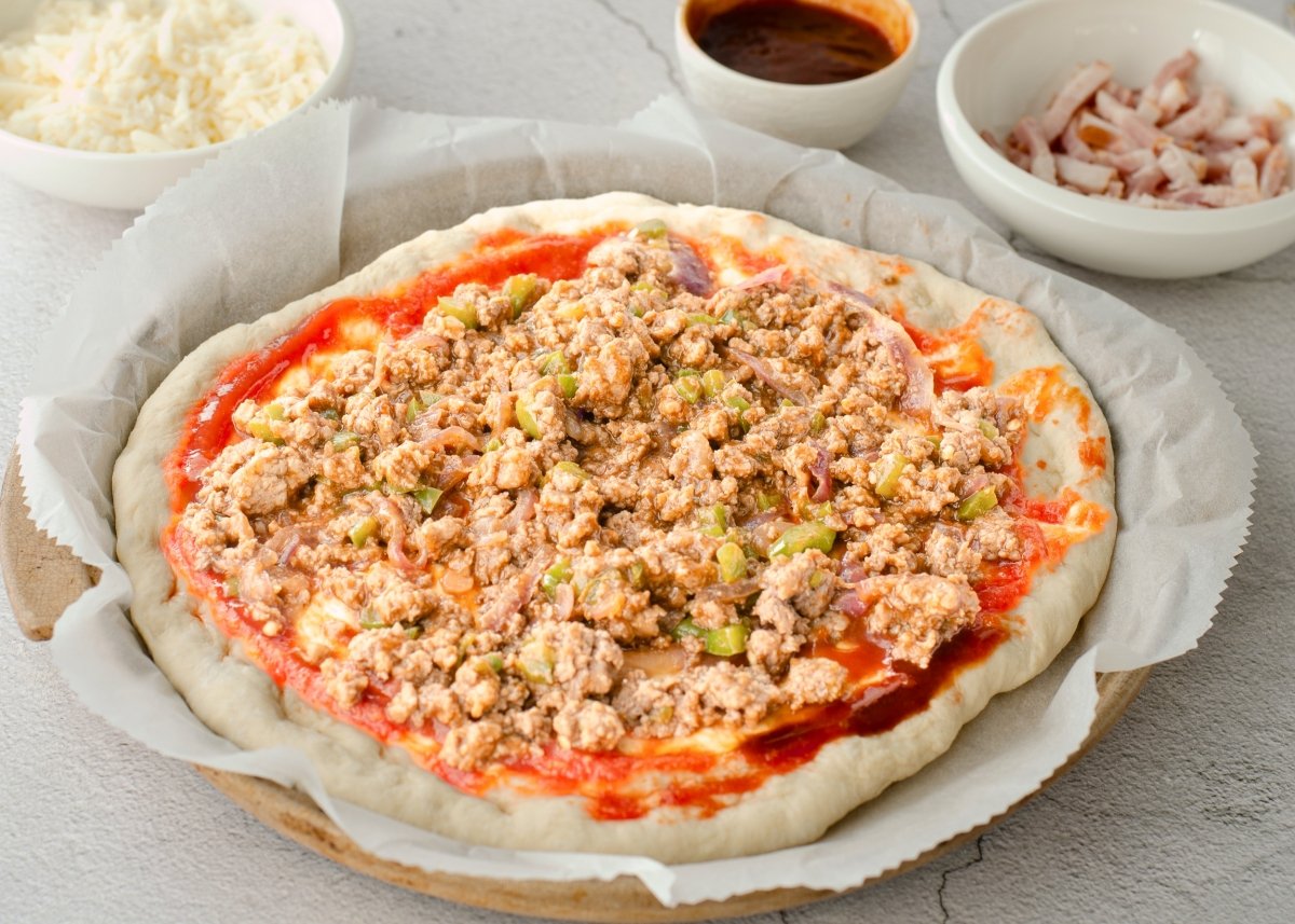 Carne picada extendida en la pizza barbacoa