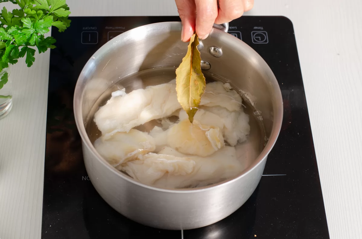 Cazo con agua y el bacalao puesto a escaldar