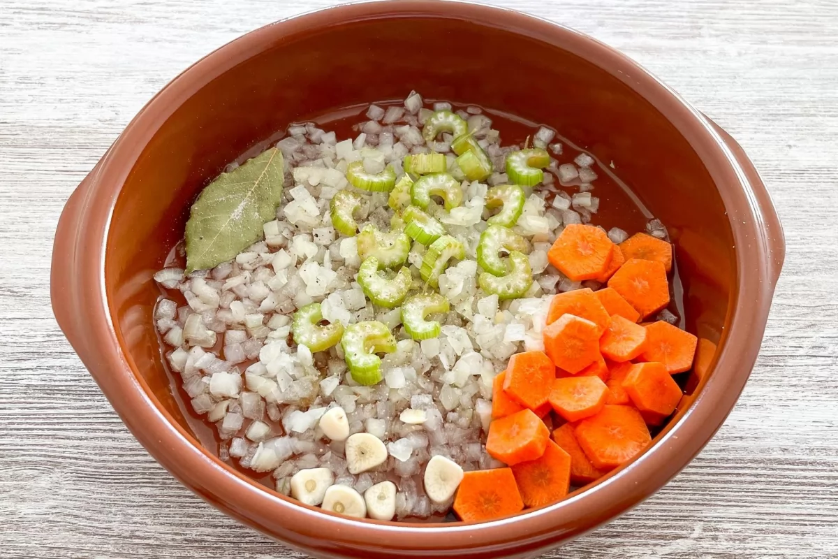 Albóndigas en salsa española al horno 3 Cazuela para hornear con ajo, cebolla, laurel, apio y zanahoria