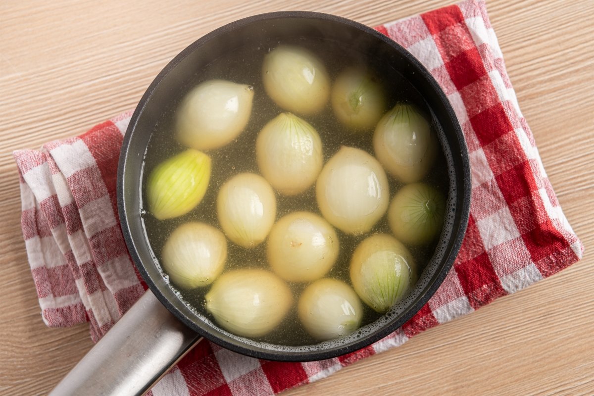 Cebollitas francesas cociéndose para el coq au vin