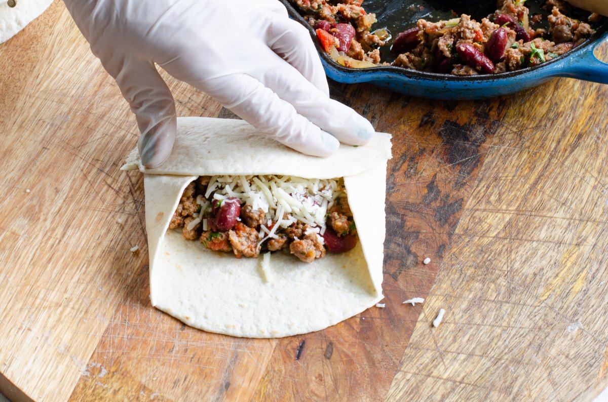 Cerrando y enrollando las tortillas para hacer las chimichanga