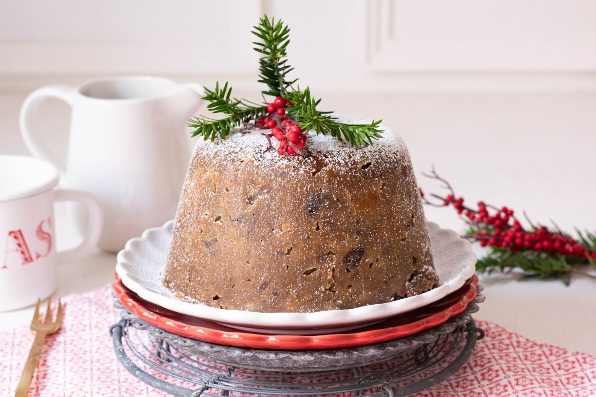Christmas pudding decorado con nueces pecanas y frambuesas
