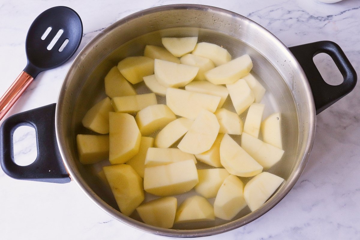 Cocer las patatas para el pastel gratinado y carne picada de pollo