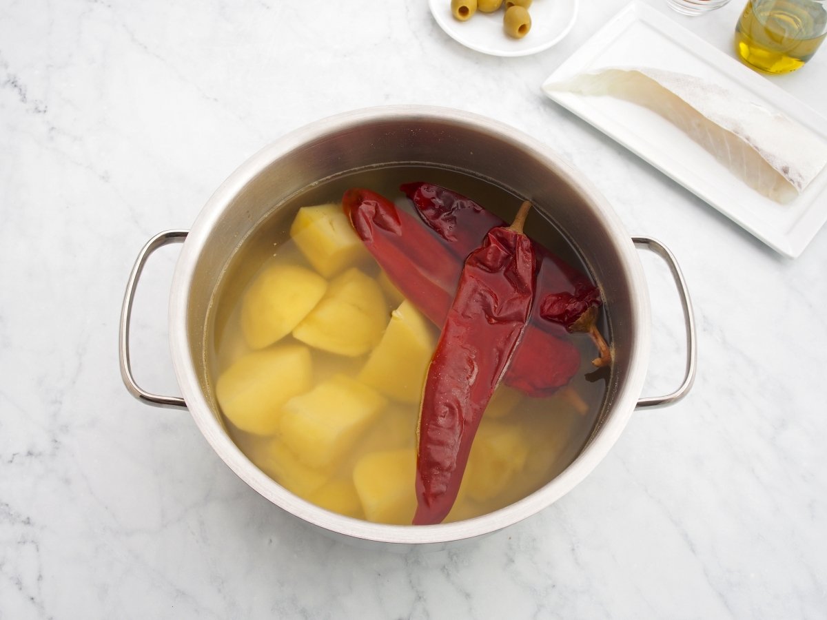 Cocer las patatas y pimientos choriceros para el rin ran de bacalao