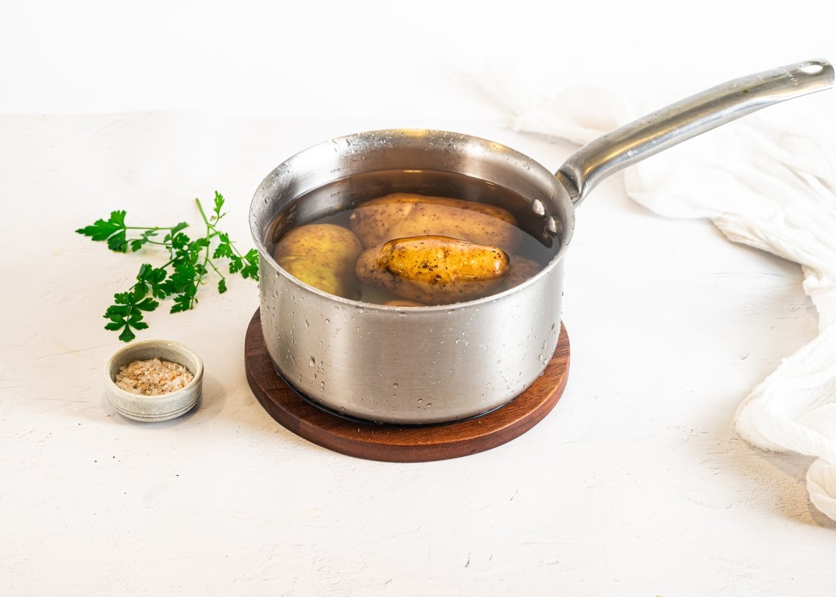 Cociendo las patatas enteras para hacer patatas enmascaradas