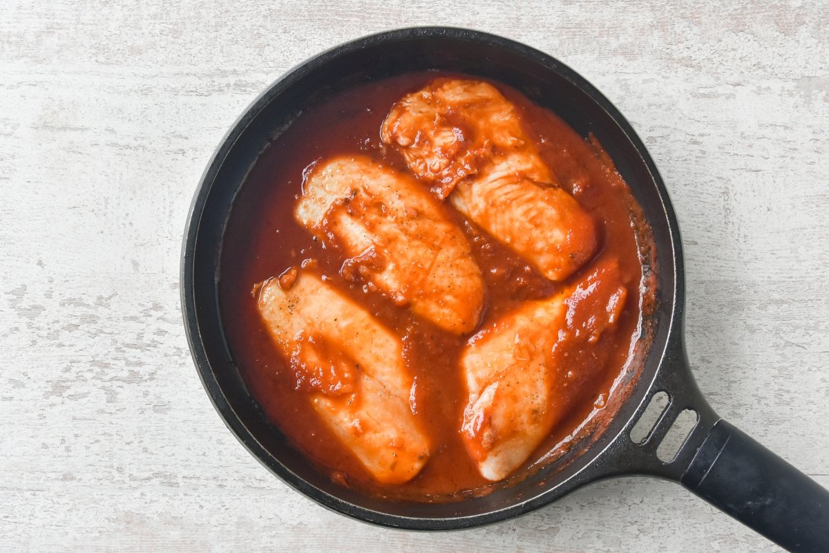 Cocinamos la merluza en la salsa de tomate