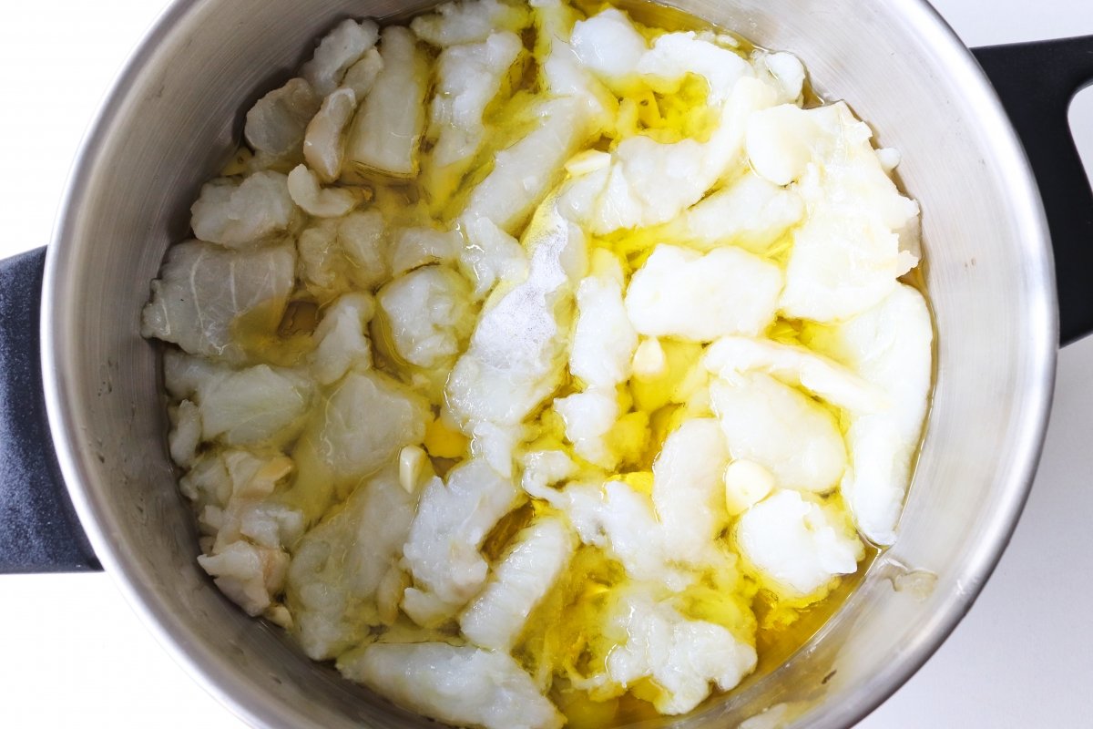 Cocinar el bacalao en el aceite para hacer la brandada de bacalao