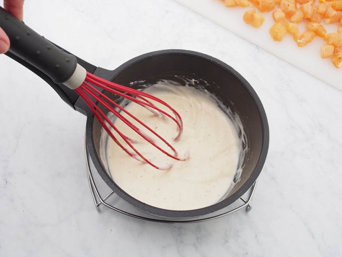 Cocinar la bechamel para el hojaldre relleno de pollo y bechamel