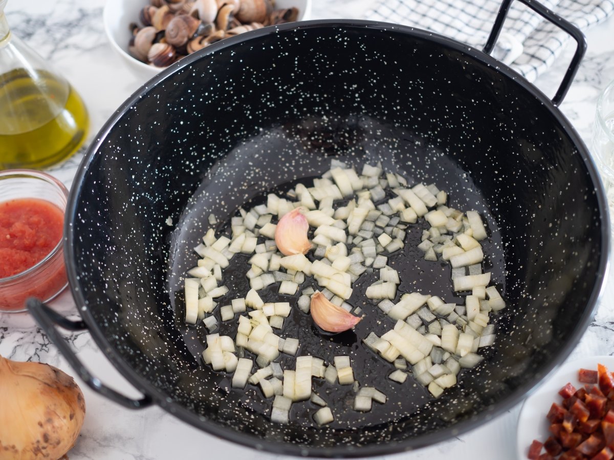 Cocinar la cebolla picada y los ajos para los caracoles picantes