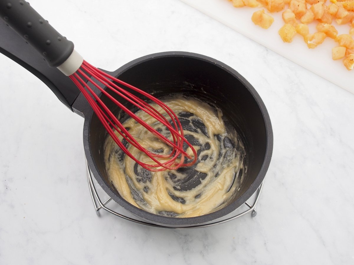 Cocinar la harina para la bechamel del hojaldre relleno de pollo y bechamel