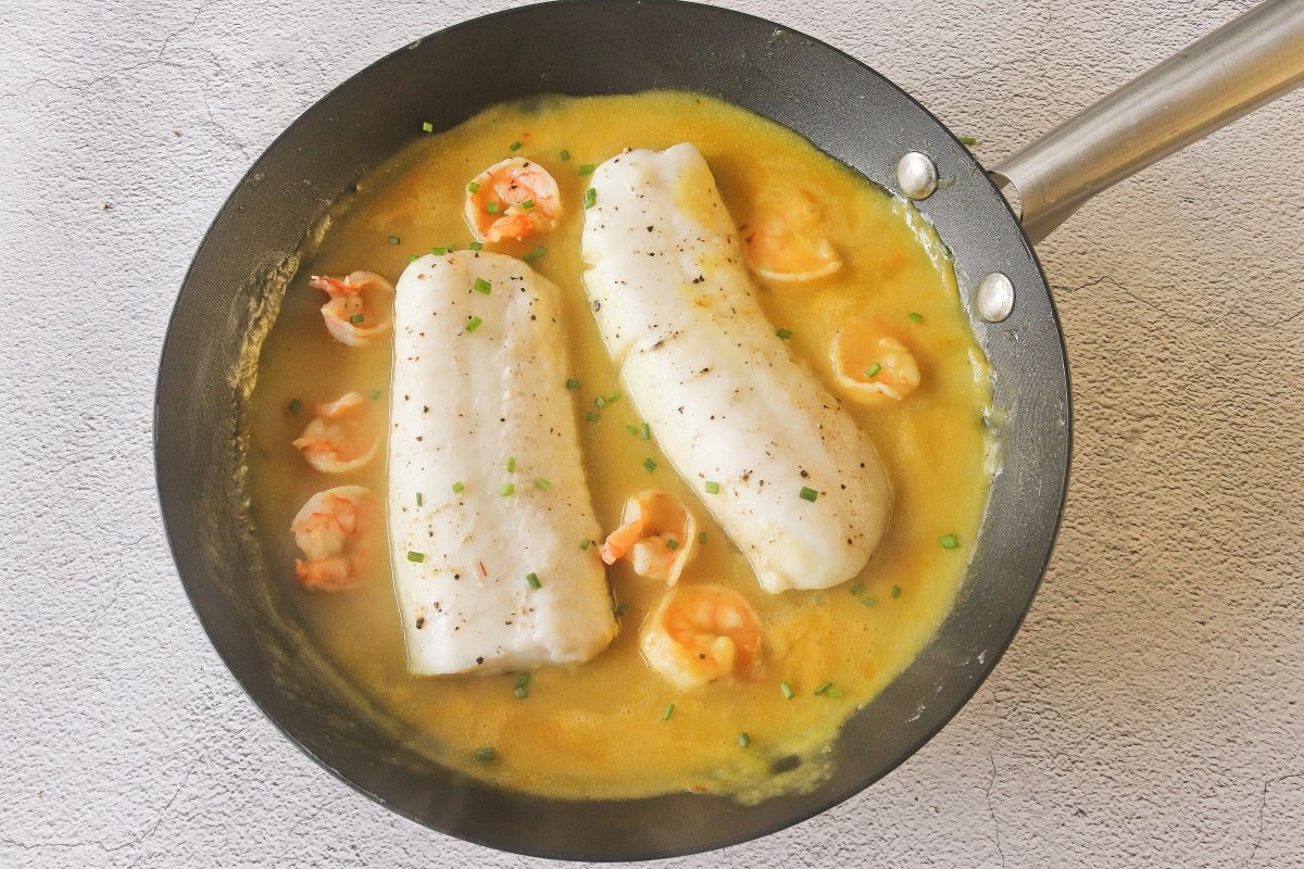 Cocinar la merluza y las gambas en la salsa de cava