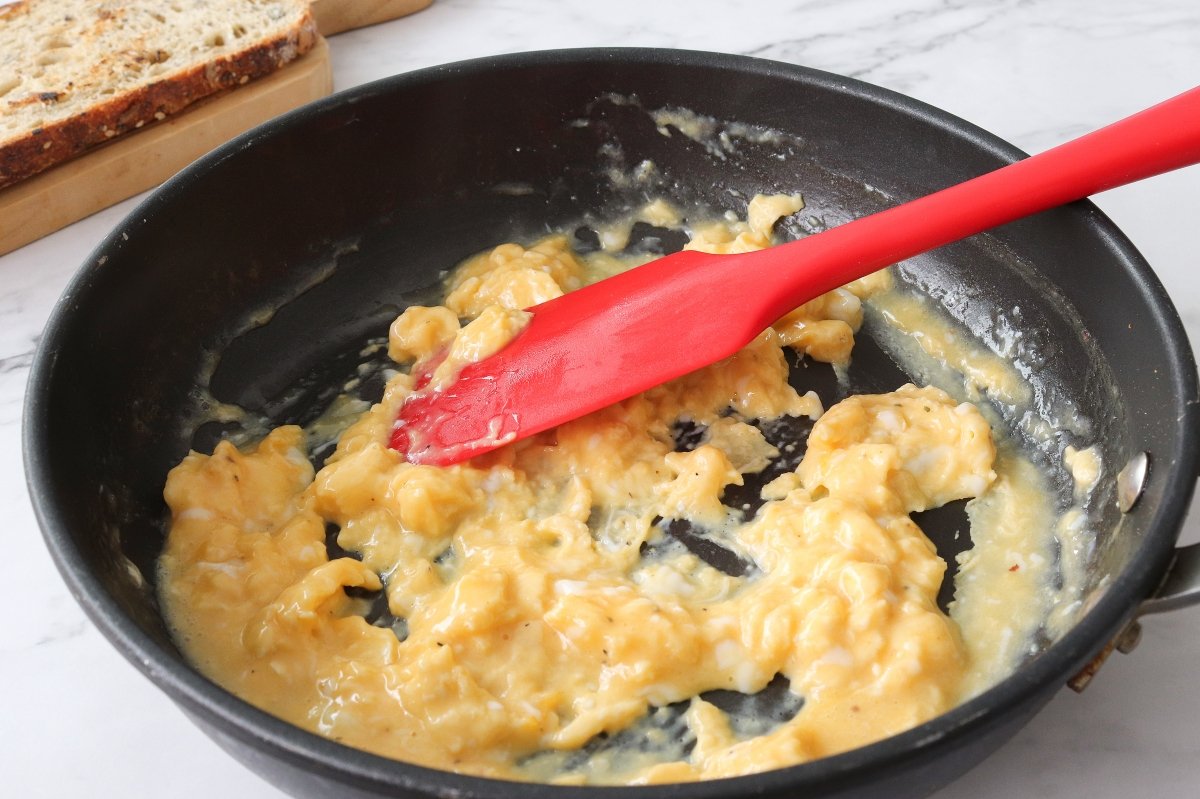 Cocinar los huevos para la tostada de huevos revueltos con jamón