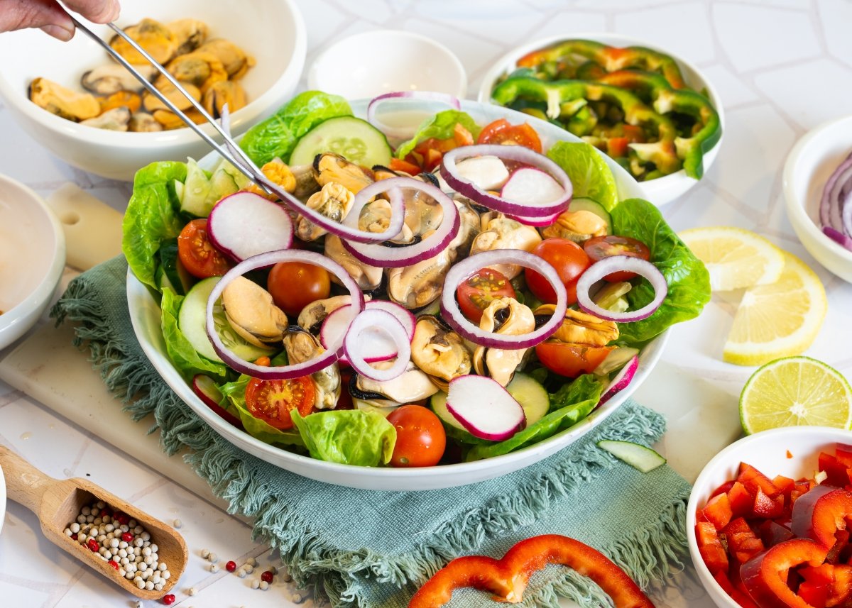 Colocamos los aros de cebolla morada a la ensalada de mejillones