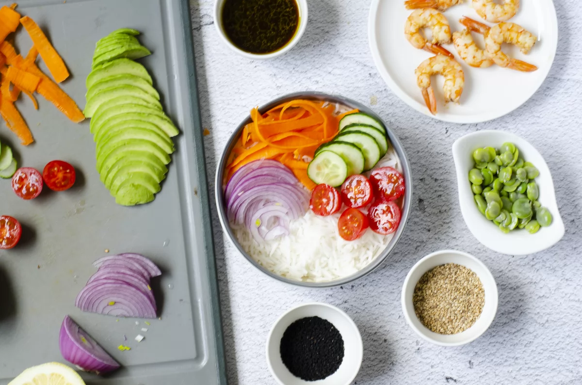 Colocando los ingredientes en el poke bowl de langostinos