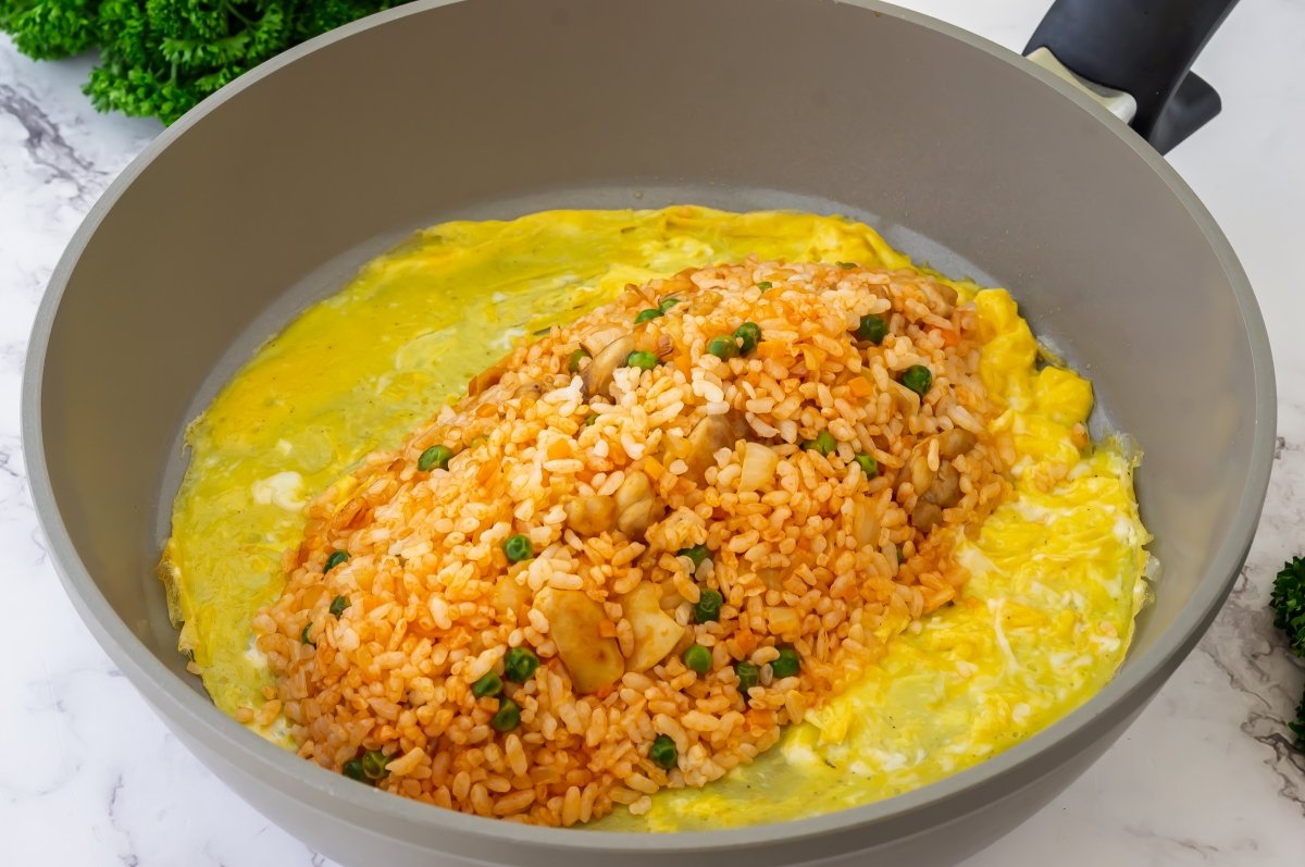 Colocar el arroz sobre la tortilla del omurice