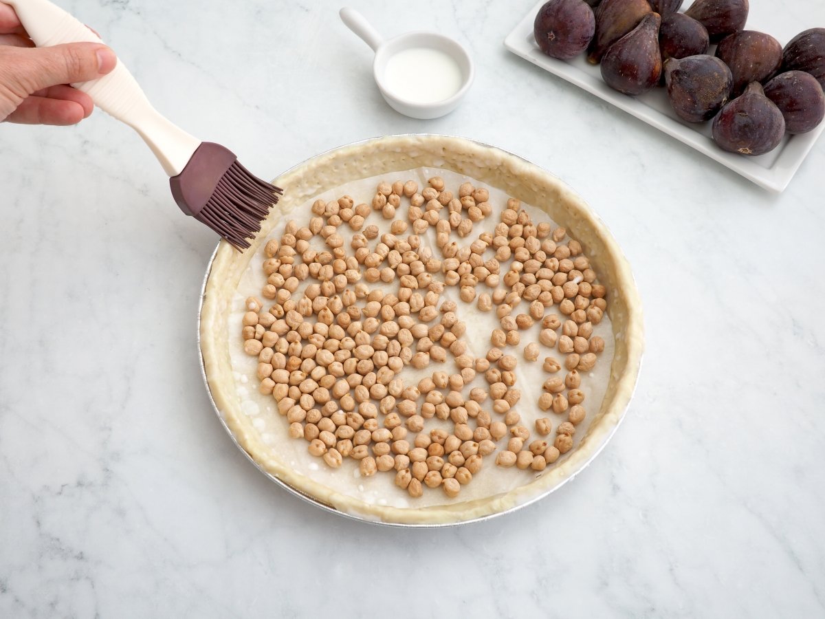 Colocar garbanzos secos en la base y pintar el hojaldre con leche