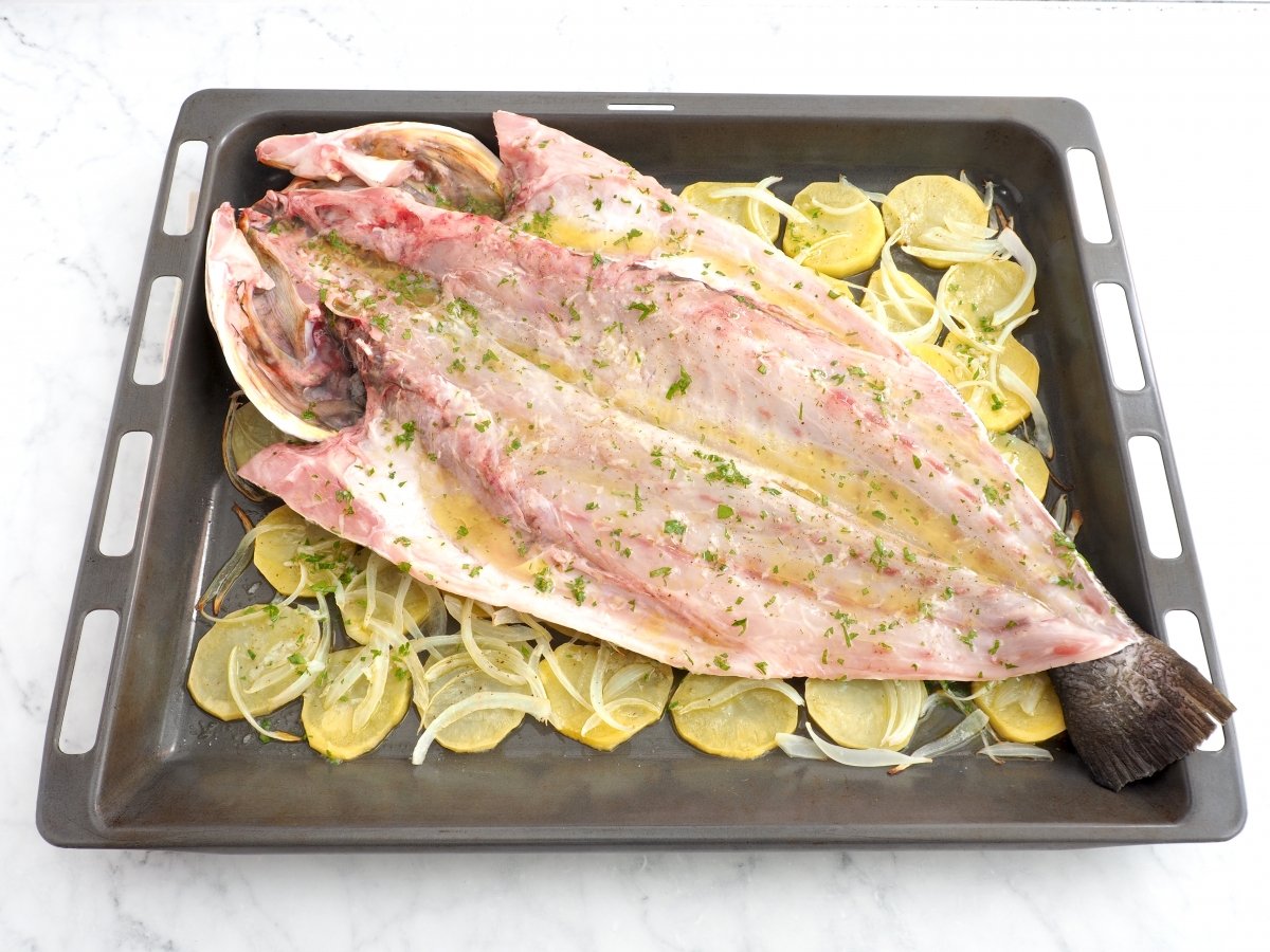 Colocar la corvina sobre la cama de patatas