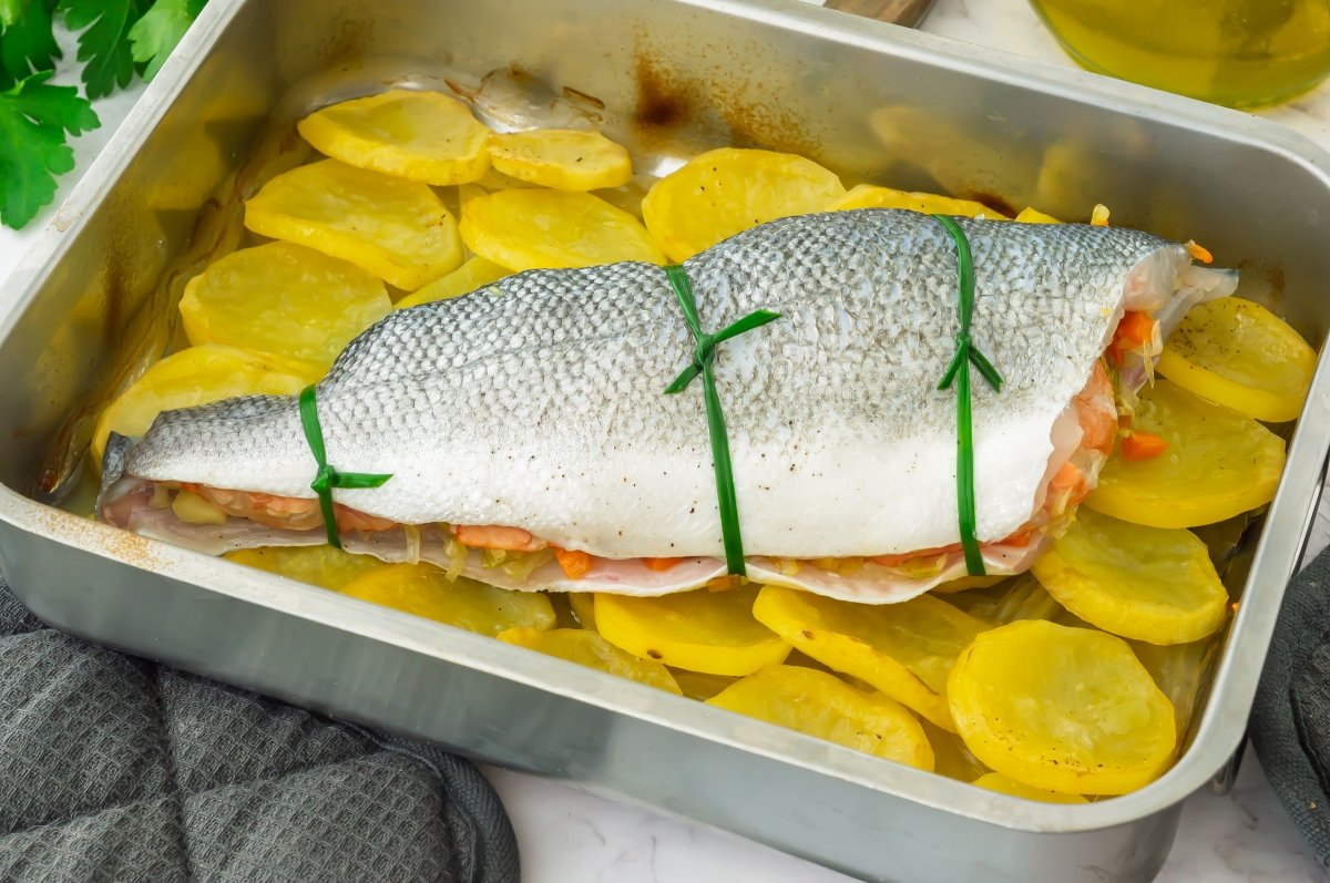 Colocar la lubina rellena sobre las patatas
