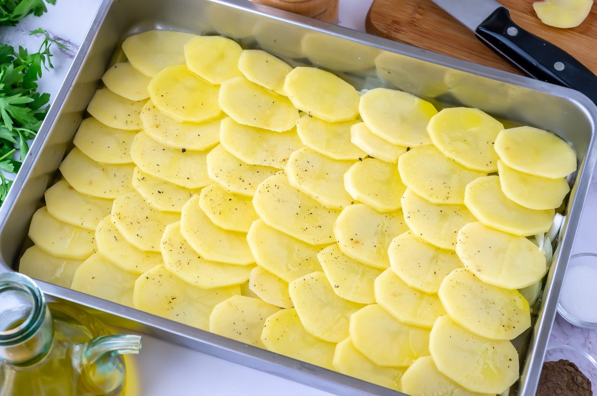 Colocar las patatas en la fuente para el fletán al horno