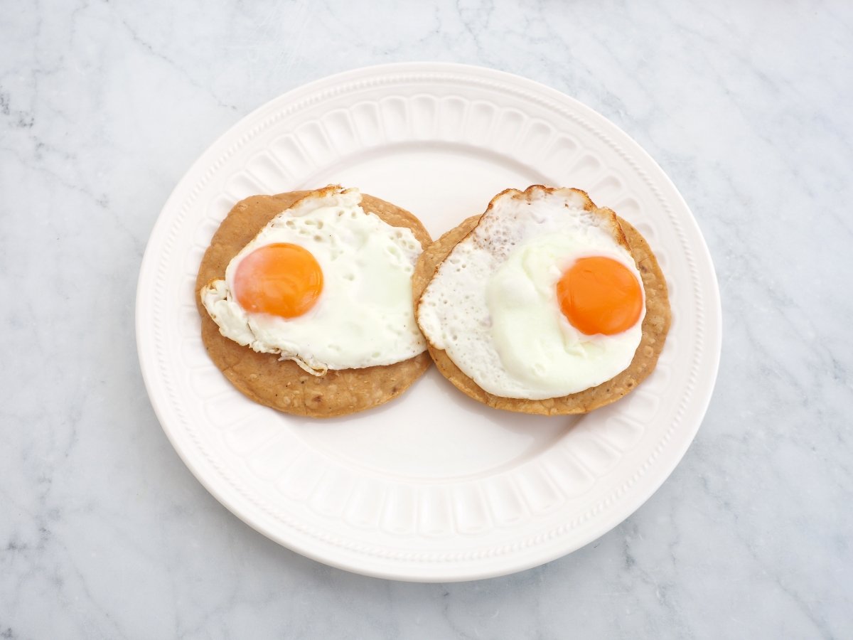 Colocar los huevos encima de las tortillas de maíz