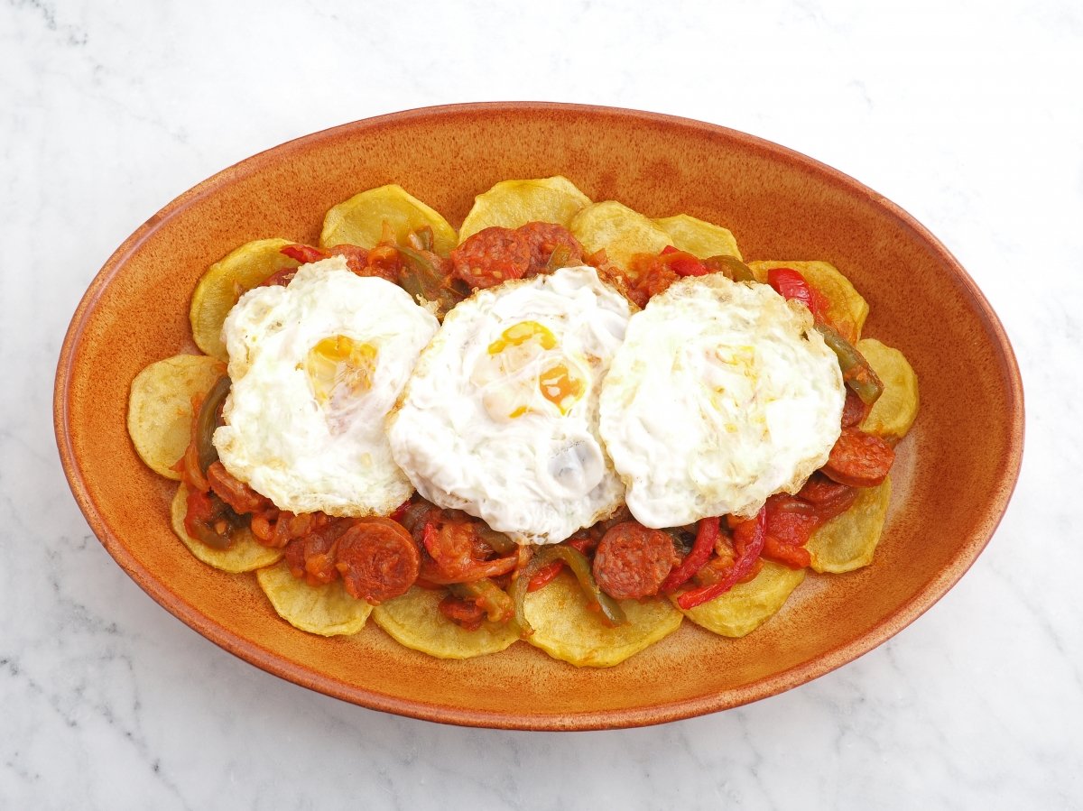Colocar los huevos fritos y servir