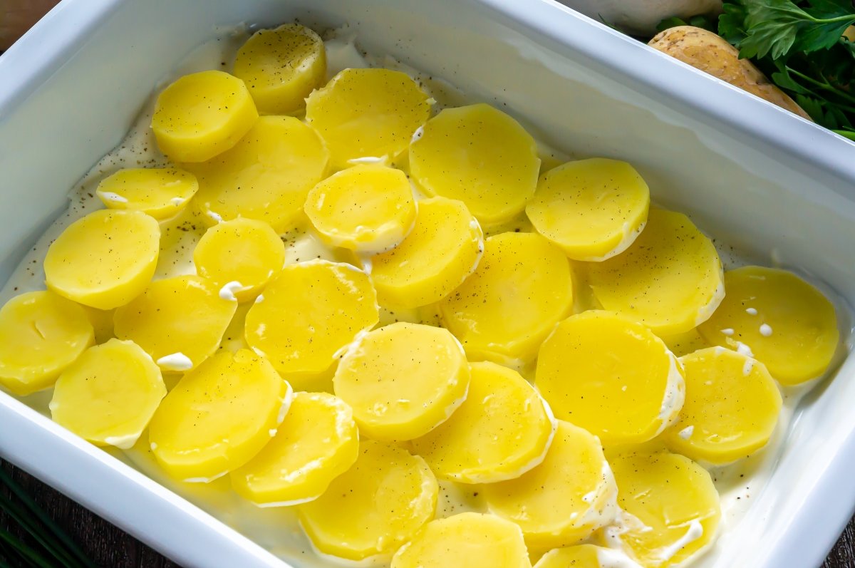 Colocar una capa de patatas en la fuente para la tartiflette